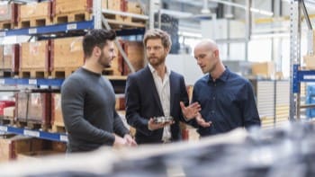 Specialized Solutions Businessmen in warehouse discussing technical part