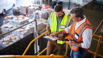 UPS Zone Solutions Men in warehouse reviewing clipboards