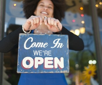 Customer Stories Small business owner holding open sign
