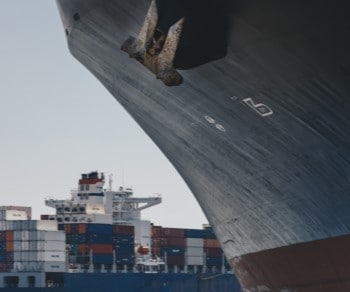 Strategies for Managing Through a Challenging Ocean Environment Close up of side of ship with container ship in background