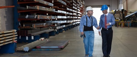 Warehouse worker and businessman in hard hats