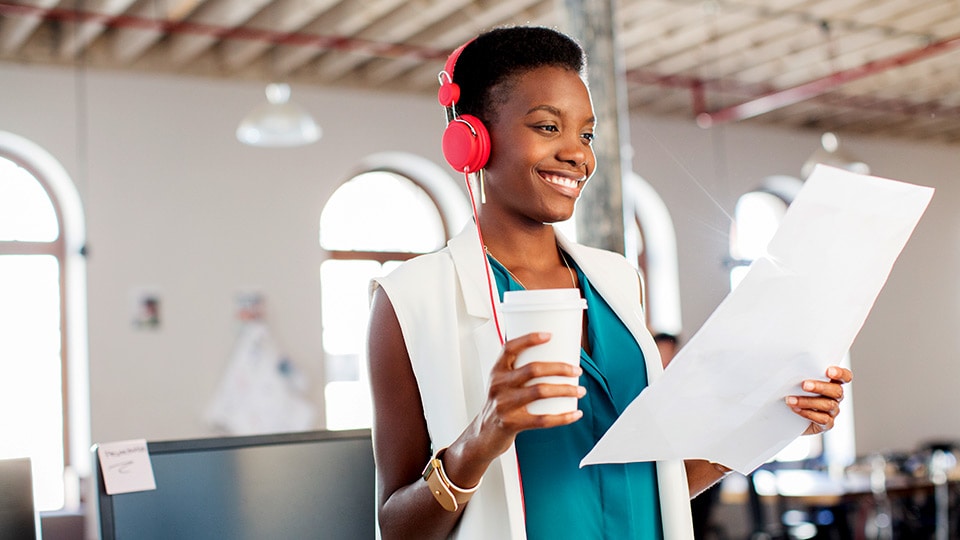 Woman with headphones reviewing a document Woman with headphones reviewing a document