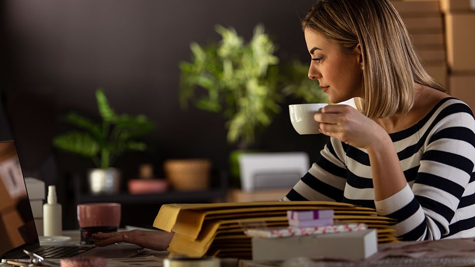 Woman drinking coffee and using her laptop. Woman drinking coffee and using her laptop.