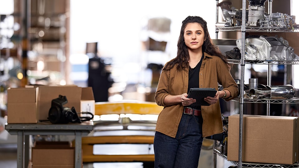 Woman leaning against a shelf holding a tablet Woman leaning against a shelf holding a tablet